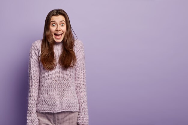 Giovane donna che indossa un maglione viola