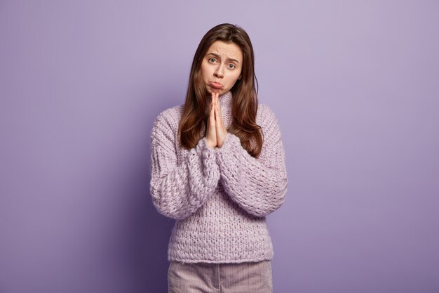 Giovane donna che indossa un maglione viola