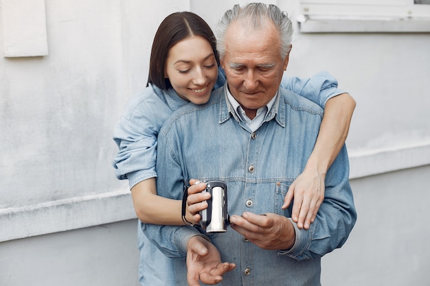 Giovane donna che insegna a suo nonno come usare una macchina fotografica