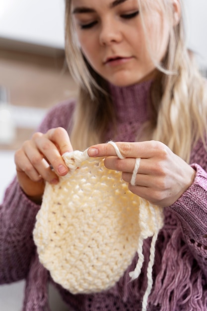 Giovane donna che lavora a maglia mentre ci si rilassa