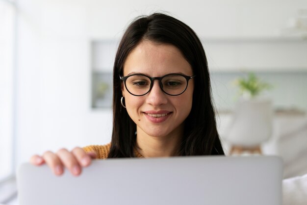 Giovane donna che lavora al suo computer portatile a casa