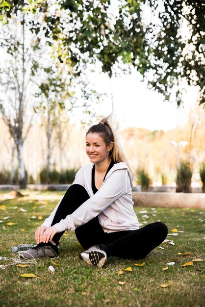 Giovane donna che lega le sue scarpe da ginnastica