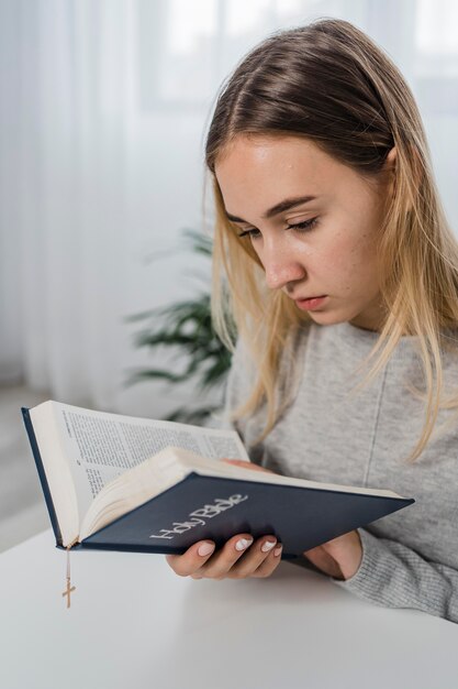 Giovane donna che legge dalla Bibbia