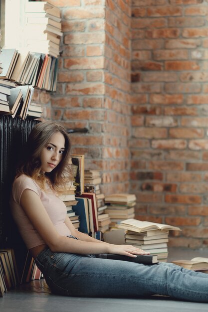 Giovane donna che legge un libro a casa