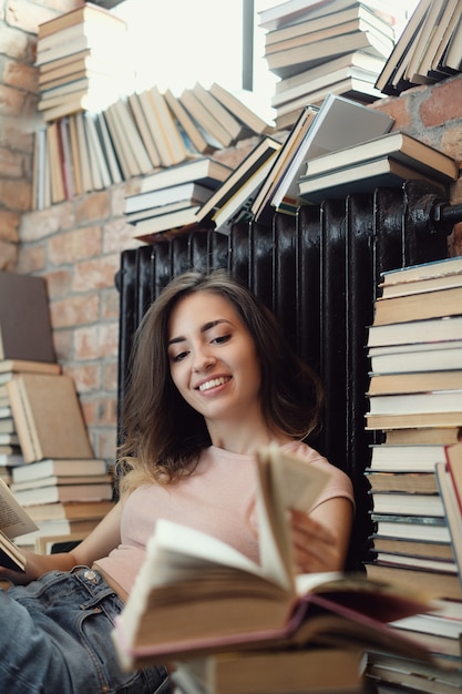 Giovane donna che legge un libro a casa