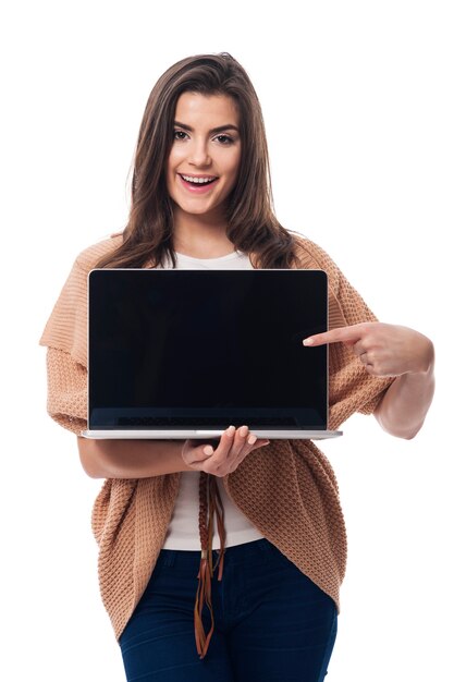 Giovane donna che mostra sullo schermo del laptop contemporaneo