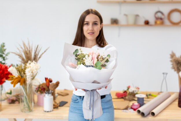 Giovane donna che mostra uno splendido mazzo di fiori