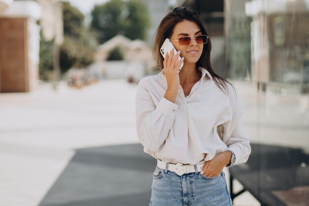 Giovane donna che parla al telefono fuori strada