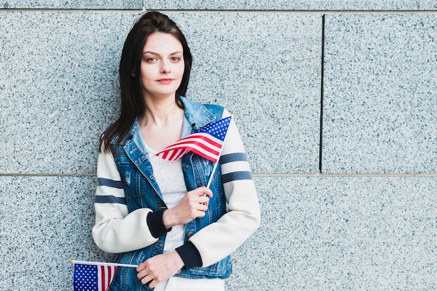 Giovane donna che posa con le bandiere americane