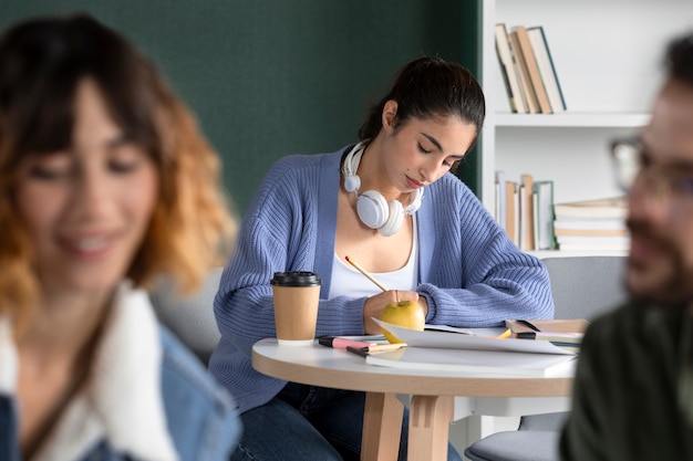 Giovane donna che prende appunti durante la sessione di studio