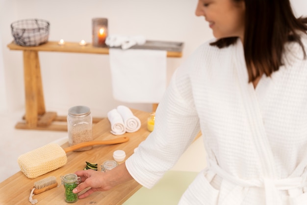 Giovane donna che prende il sale da bagno per metterne un po' nell'acqua prima di fare il bagno