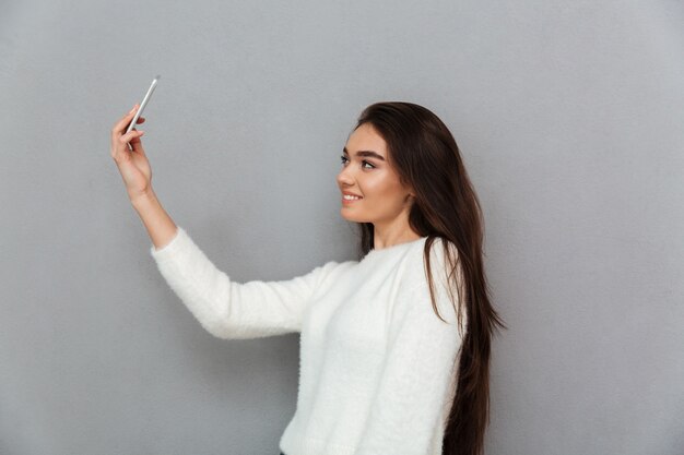 Giovane donna che prende selfie