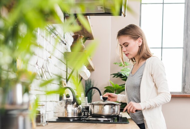 Giovane donna che prepara il cibo in cucina