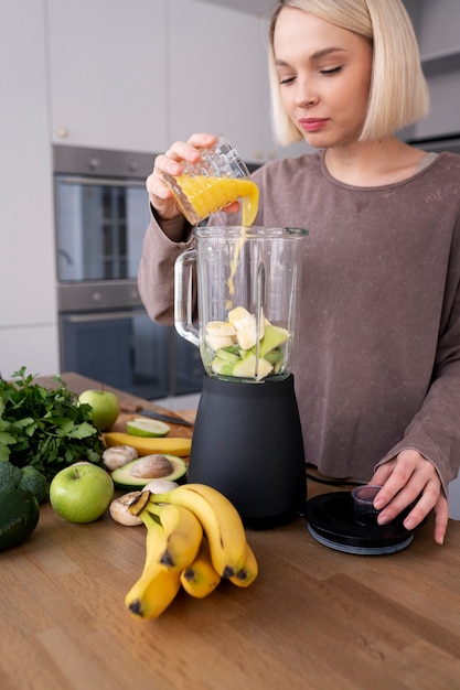 Giovane donna che prepara la sua dieta nutrizionale