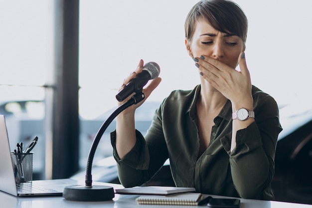 Giovane donna che registra la voce che agisce in studio