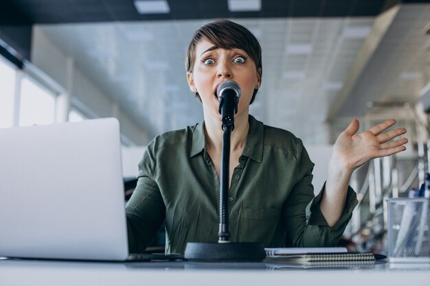 Giovane donna che registra la voce che agisce in studio