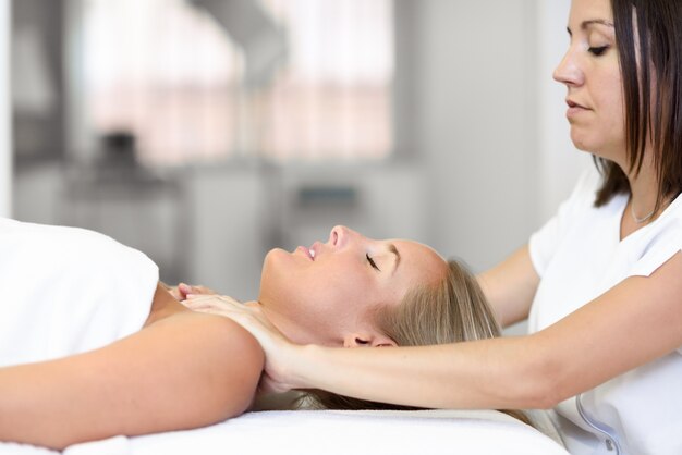 Giovane donna che riceve un massaggio alla testa in un centro termale.