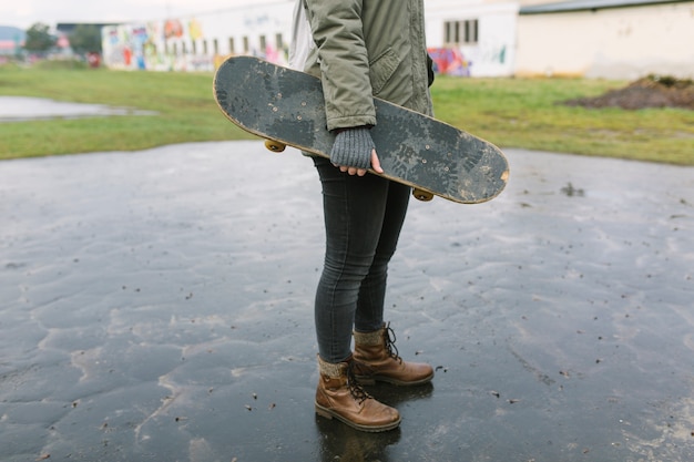 Giovane donna che salta su skateboard