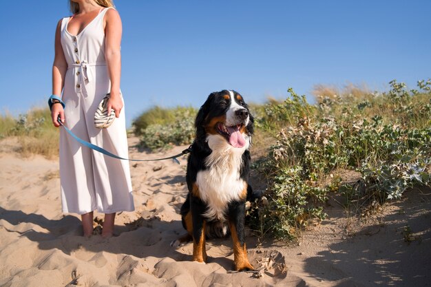 Giovane donna che si diverte con il cane in spiaggia