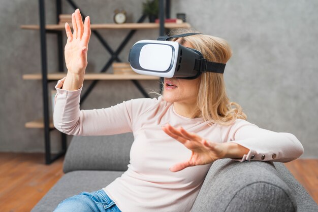 Giovane donna che si diverte con la nuova tecnologia vr auricolare occhiali