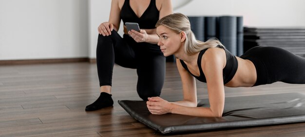 Giovane donna che si esercita in palestra facendo una plancia