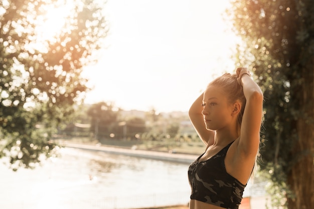 Giovane donna che si estende nel parco