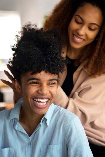 Giovane donna che si prende cura dei capelli afro del ragazzo