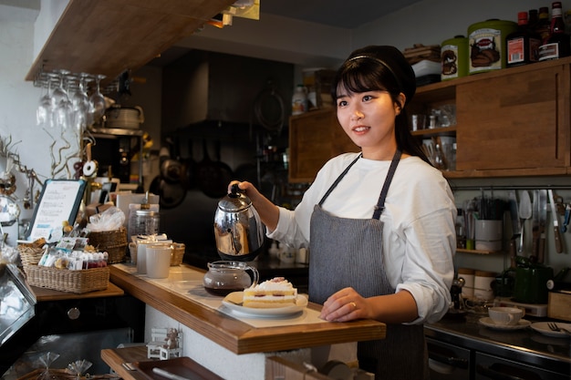 Giovane donna che sistema la sua pasticceria