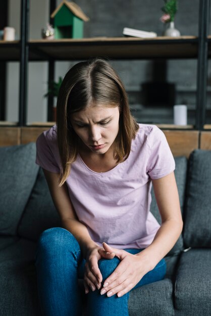 Giovane donna che soffre di dolore al ginocchio