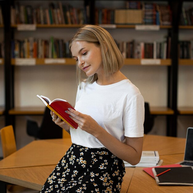 Giovane donna che studia in biblioteca