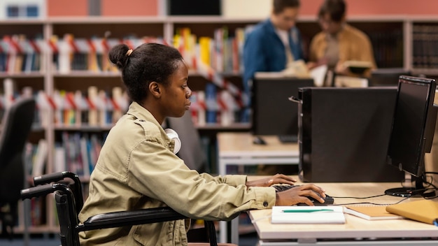 Giovane donna che studia in biblioteca