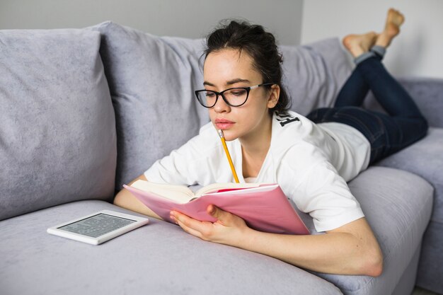 Giovane donna che studia sul divano