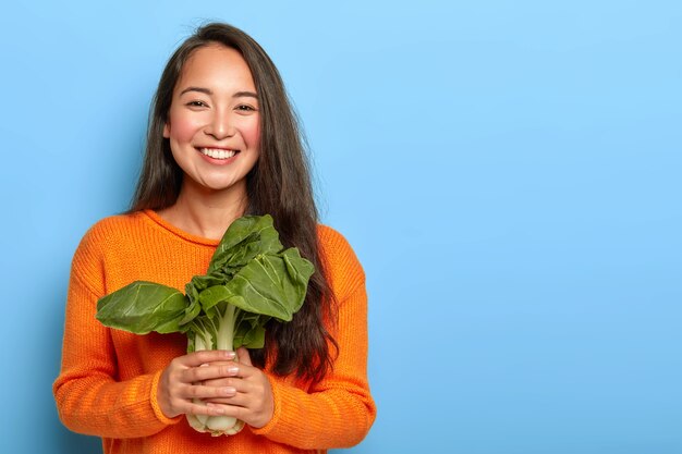 Giovane donna che tiene i fogli verdi