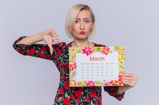 giovane donna che tiene il calendario cartaceo del mese di marzo