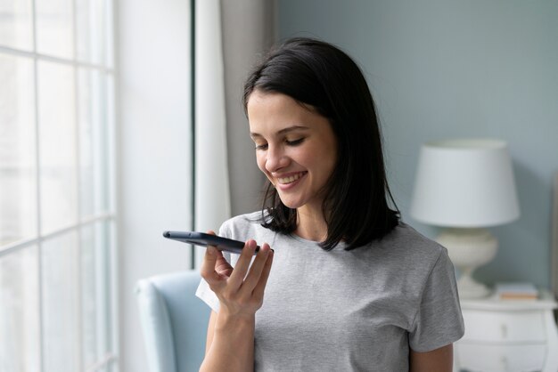 Giovane donna che tiene il suo telefono