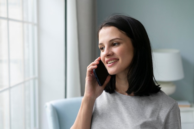 Giovane donna che tiene il suo telefono