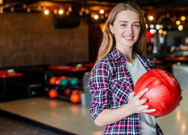 Giovane donna che tiene la palla da bowling
