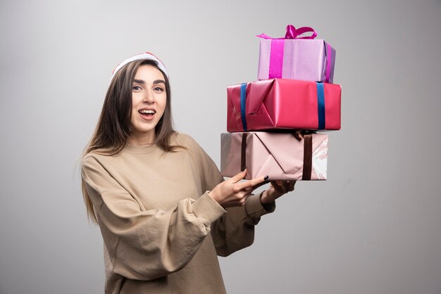 Giovane donna che tiene tre scatole di regali di Natale.
