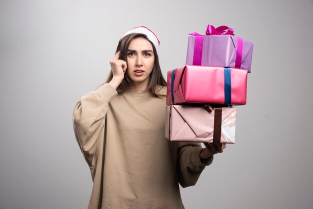 Giovane donna che tiene tre scatole di regali di Natale.