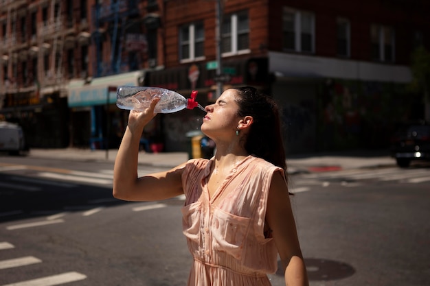 Giovane donna che tollera l'ondata di caldo con una bevanda fresca