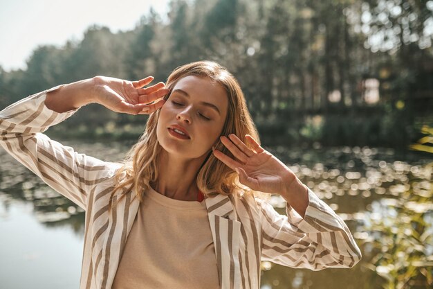 Giovane donna che trascorre una giornata nel parco vicino all'acqua