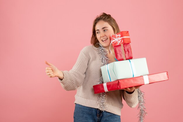 giovane donna che trasportano regali di Natale in rosa