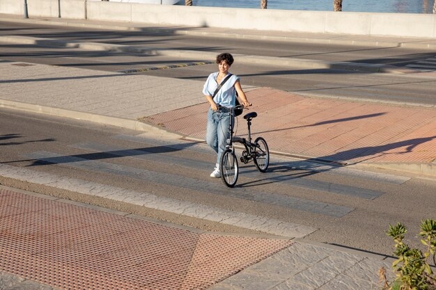 Giovane donna che usa la sua bicicletta pieghevole