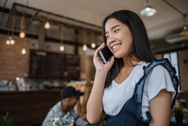 Giovane donna che usando e guardando smartphone con sentirsi felice