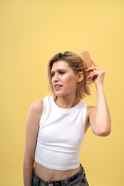 Giovane donna che utilizza il pettine