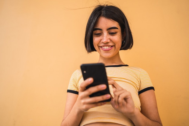 Giovane donna che utilizza il suo telefono cellulare.