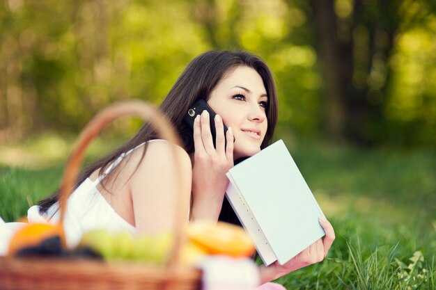 Giovane donna che utilizza un telefono sul prato