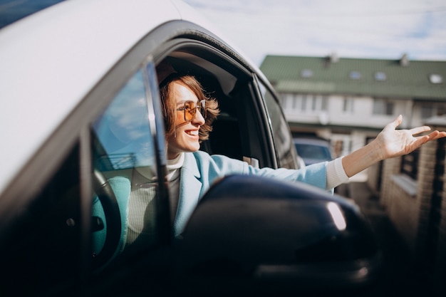 Giovane donna che viaggia in auto elettrica