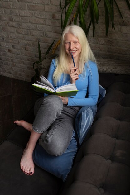 Giovane donna con albinismo e libro