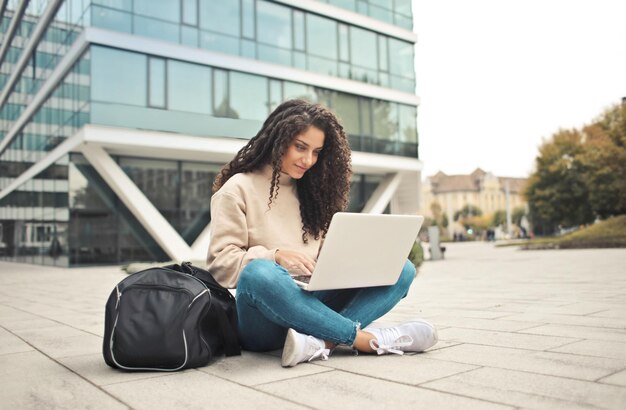 giovane donna con borsa da palestra e computer in strada